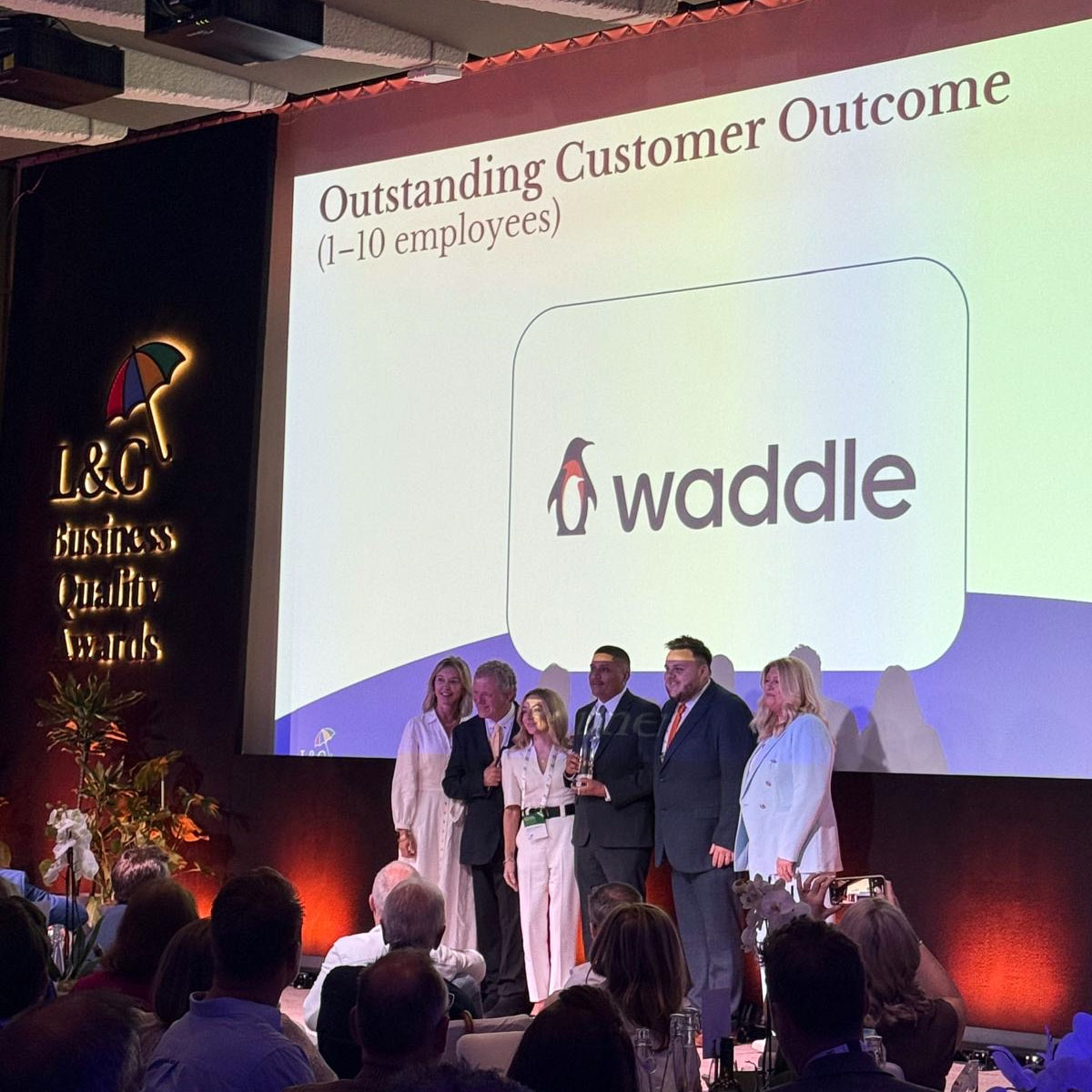 Waddle team receiving the L&G Business Quality Awards 2025 trophy for Outstanding Customer Outcome (1 - 10 employees)
